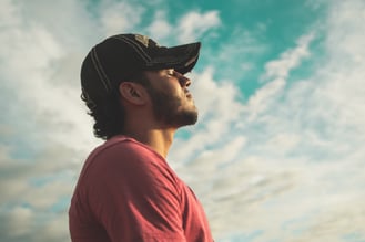 Man under blue sky breathing 