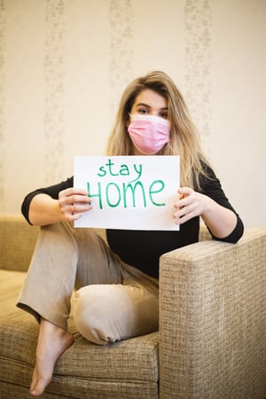 Women in mask holding sign